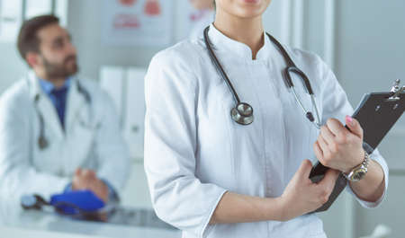 Woman doctor standing with stethoscope at hospitalの写真素材