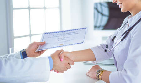 Doctor shakes hands with a patient isolated on white backgroundの写真素材