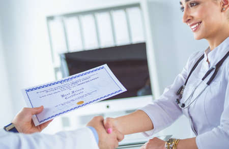 Doctor shakes hands with a patient isolated on white backgroundの写真素材