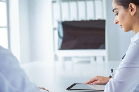 Successful medical doctors are discussing documents and smiling during the conferenceの写真素材