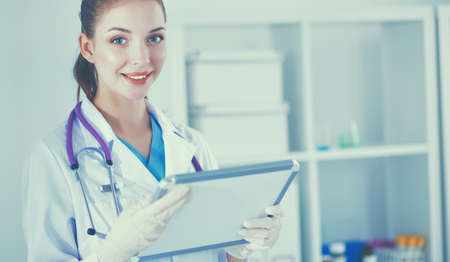 Woman doctor standing with folder at hospitalの写真素材