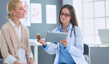 Doctor and patient discussing something while sitting at the table . Medicine and health care conceptの写真素材