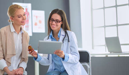 Doctor and patient discussing something while sitting at the table . Medicine and health care conceptの写真素材