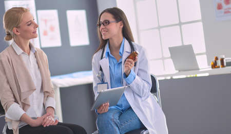 Doctor and patient discussing something while sitting at the table . Medicine and health care conceptの写真素材