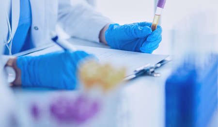 Woman researcher is surrounded by medical vials and flasks, isolated on white backgroundの写真素材