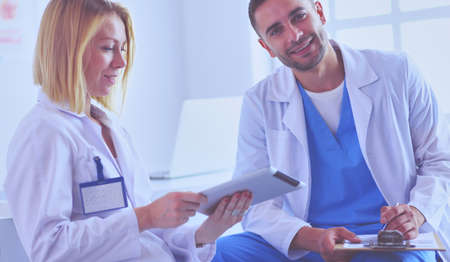 Handsome doctor is talking with young female doctor and making nの写真素材