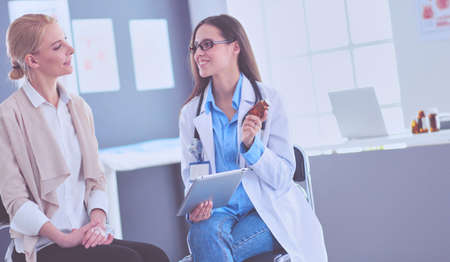Doctor and patient discussing something while sitting at the table . Medicine and health care conceptの写真素材