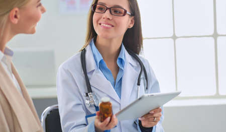 Doctor and patient discussing something while sitting at the table . Medicine and health care conceptの写真素材