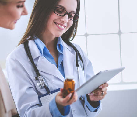 Doctor and patient discussing something while sitting at the table . Medicine and health care conceptの写真素材