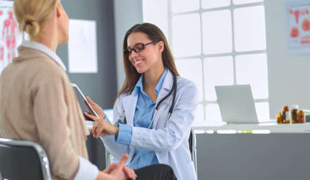 Doctor and patient discussing something while sitting at the table . Medicine and health care conceptの写真素材