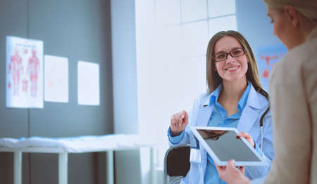 Doctor and patient discussing something while sitting at the table . Medicine and health care conceptの写真素材