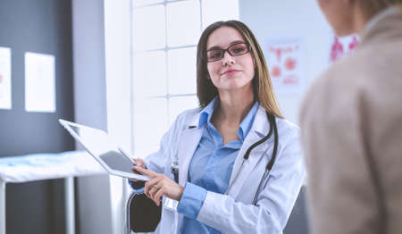 Doctor and patient discussing something while sitting at the table . Medicine and health care conceptの写真素材