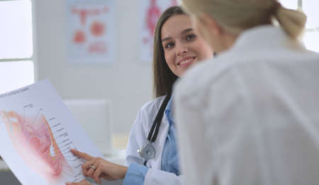Doctor and patient discussing something while sitting at the table . Medicine and health care conceptの写真素材