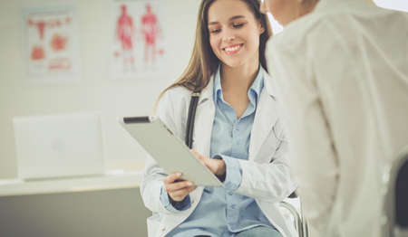 Doctor and patient discussing something while sitting at the table . Medicine and health care conceptの写真素材