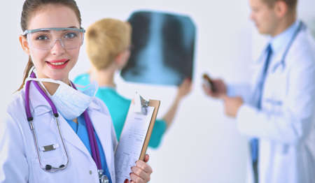 Woman doctor standing with folder at hospitalの写真素材
