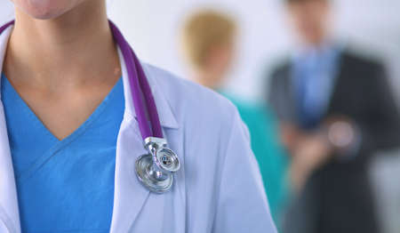 Woman doctor standing with stethoscope at hospitalの写真素材