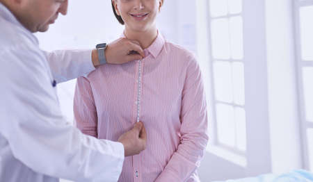 Doctor showing young patient her chest in his office at the hospitalの写真素材