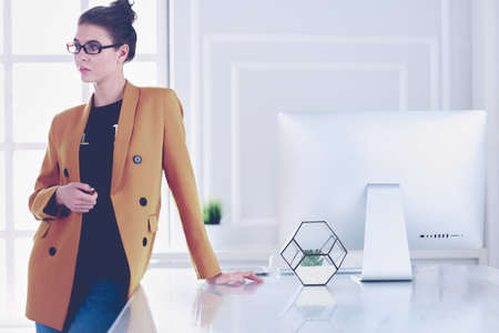 Portrait of a beautiful business woman standing near her workplaceの写真素材