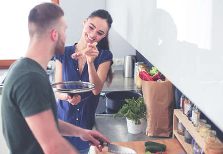 Couple cooking together in their kitchen at homeの写真素材