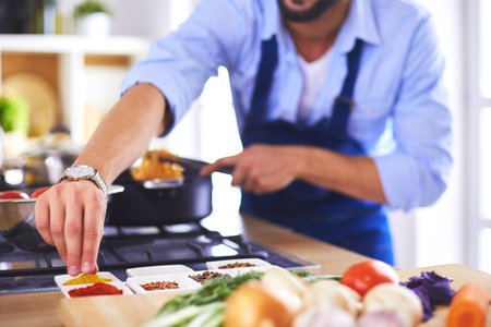 Man preparing delicious and healthy food in the home kitchenの写真素材