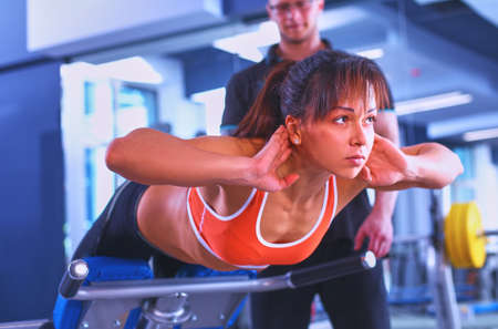 Beautiful woman at the gym exercising with her trainerの写真素材