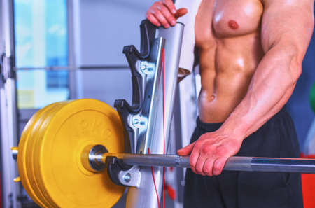 Young handsome man sits after workout in the gymの写真素材