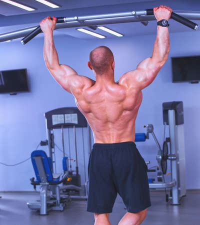 Young man training at gym with exercisesの写真素材
