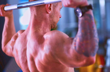 Bodybuilder with barbell in gymの写真素材