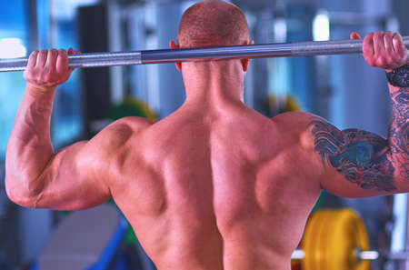 Bodybuilder with barbell in gymの写真素材