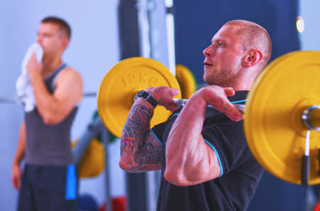 Bodybuilder with barbell in gymの写真素材