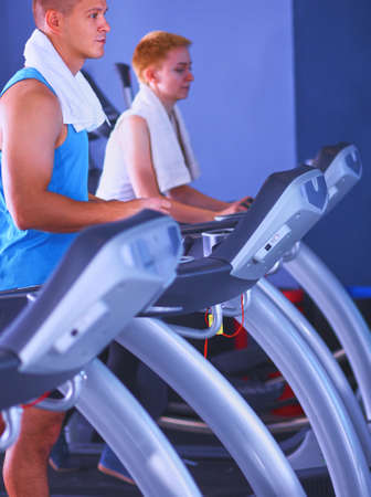Group of people at the gym exercising on cross trainersの写真素材