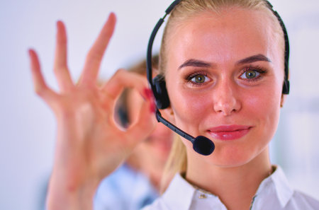 Smiling customer service girl showing ok, isolated on white background.の写真素材