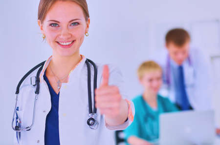Female doctor shows a sign okay standing in hospitalの写真素材