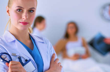 Woman doctor standing with stethoscope at hospitalの写真素材