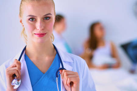 Woman doctor standing with stethoscope at hospitalの写真素材