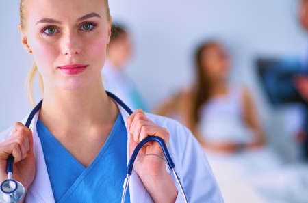 Woman doctor standing with stethoscope at hospitalの写真素材