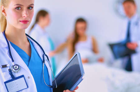 Woman doctor standing with folder at hospitalの写真素材