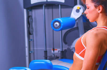 Beautiful girl at the gym exercising on trainersの写真素材