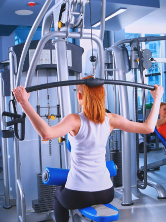 Beautiful girl at the gym exercising on trainersの写真素材