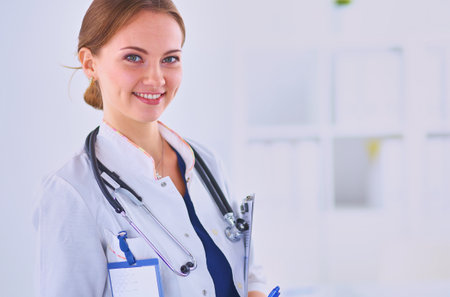 Woman doctor standing with folder at hospitalの写真素材