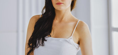 Beautiful brunette lying on bed at home.の写真素材