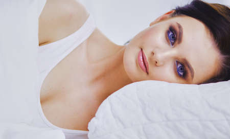 Young beautiful woman lying in bed.の写真素材