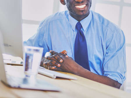 Businessman holding house miniature on hand standing in office.の写真素材