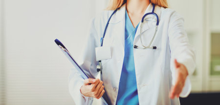 Portrait of woman doctor with folder at hospital corridorの写真素材