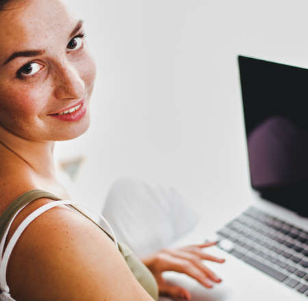 A young colledge girl sitting on the floor with a laptopの写真素材