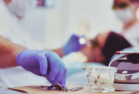 Senior male dentist adjust searchlight before starting workの写真素材