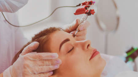 A young girl having red lips permanent makeup, micropigmentationの写真素材