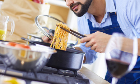 Man preparing delicious and healthy food in the home kitchenの写真素材