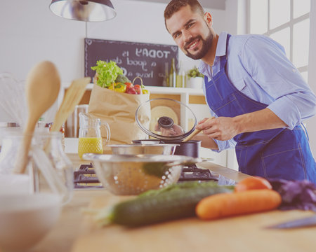 Man preparing delicious and healthy food in the home kitchenの写真素材