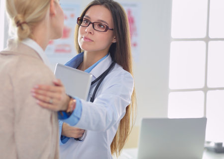 Doctor and patient discussing something while sitting at the table . Medicine and health care conceptの写真素材